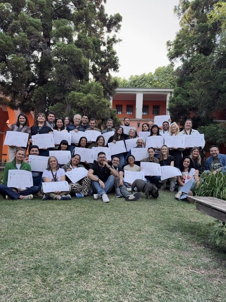 Egresados de la Formación posan con sus certificados en el jardín