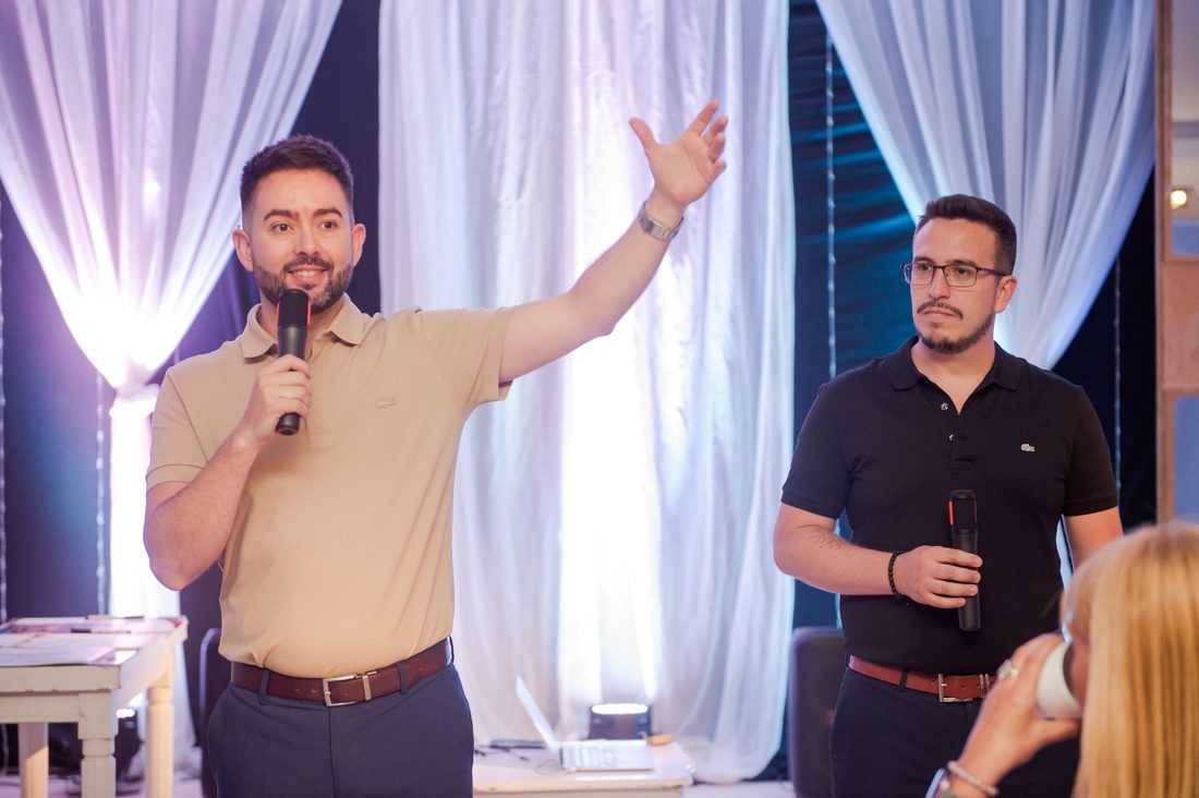 Edu Rodríguez y Juan Pablo Moyano hablando con micrófono frente al grupo