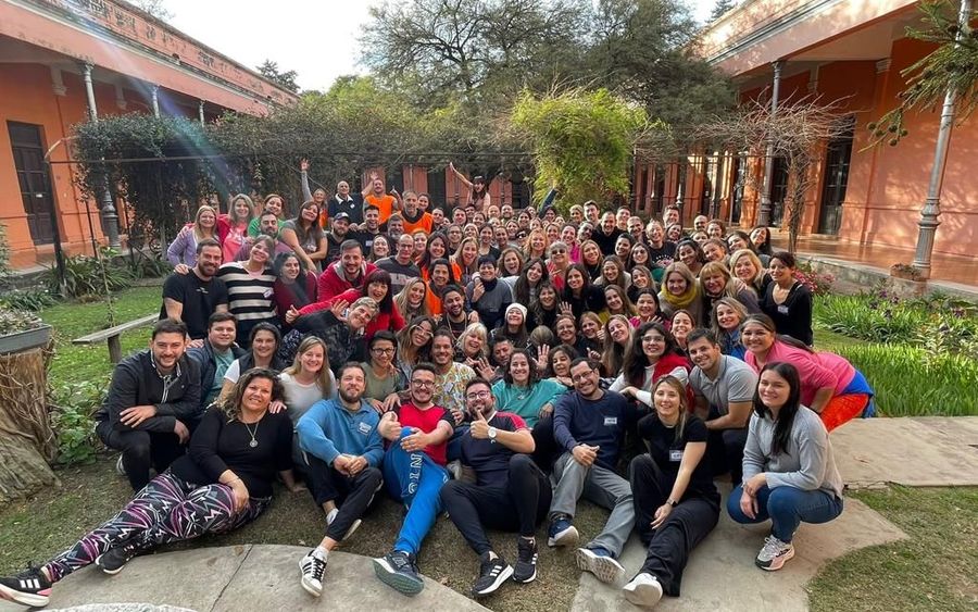 Estudiantes y entrenadores de la Formación sentados en el jardín de la sede