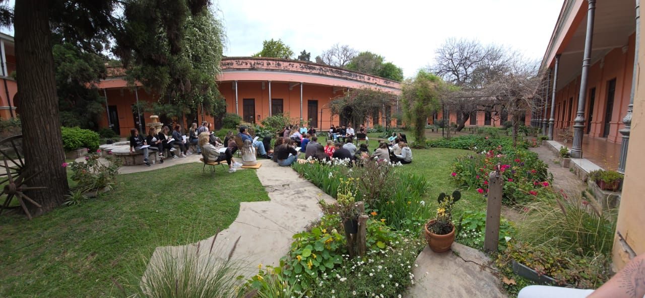 Estudiantes en el jardín de la sede, entre canteros y galerías