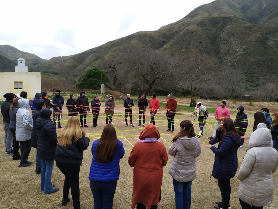 Un grupo teje una red de hilos de colores en un valle entre las sierras