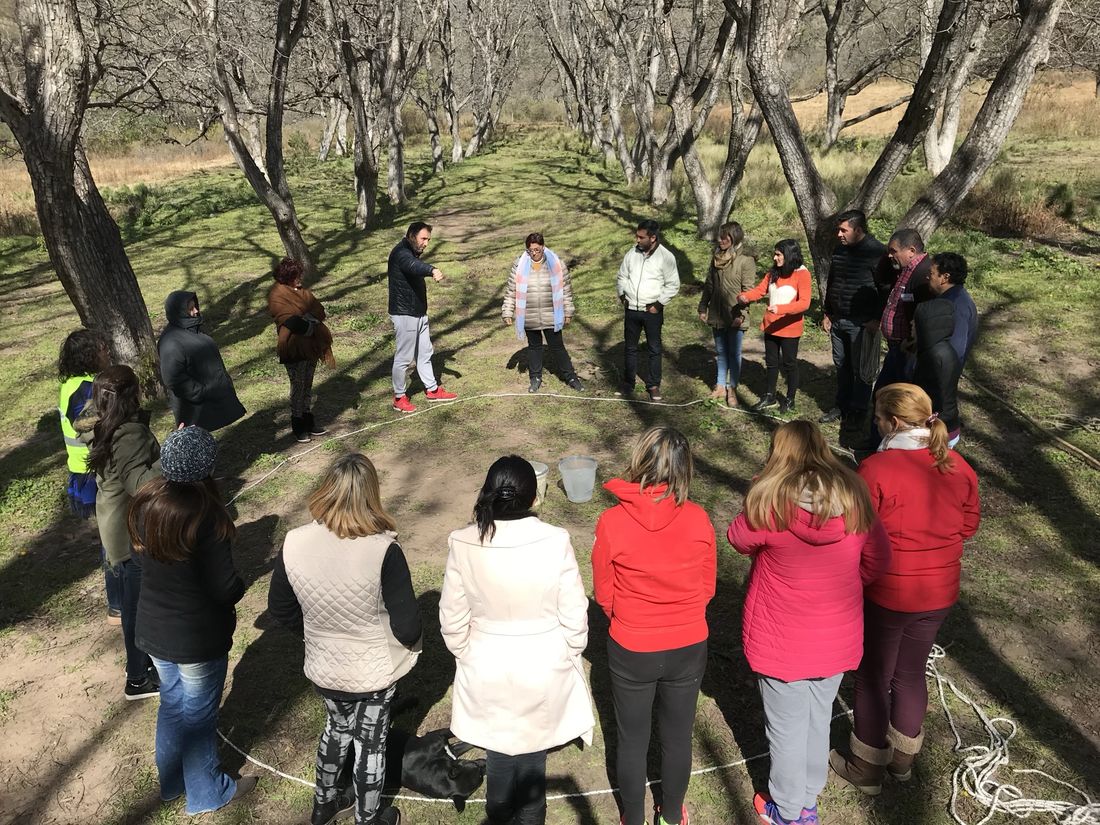 Estudiantes en ronda dentro de un círculo de soga, en el monte